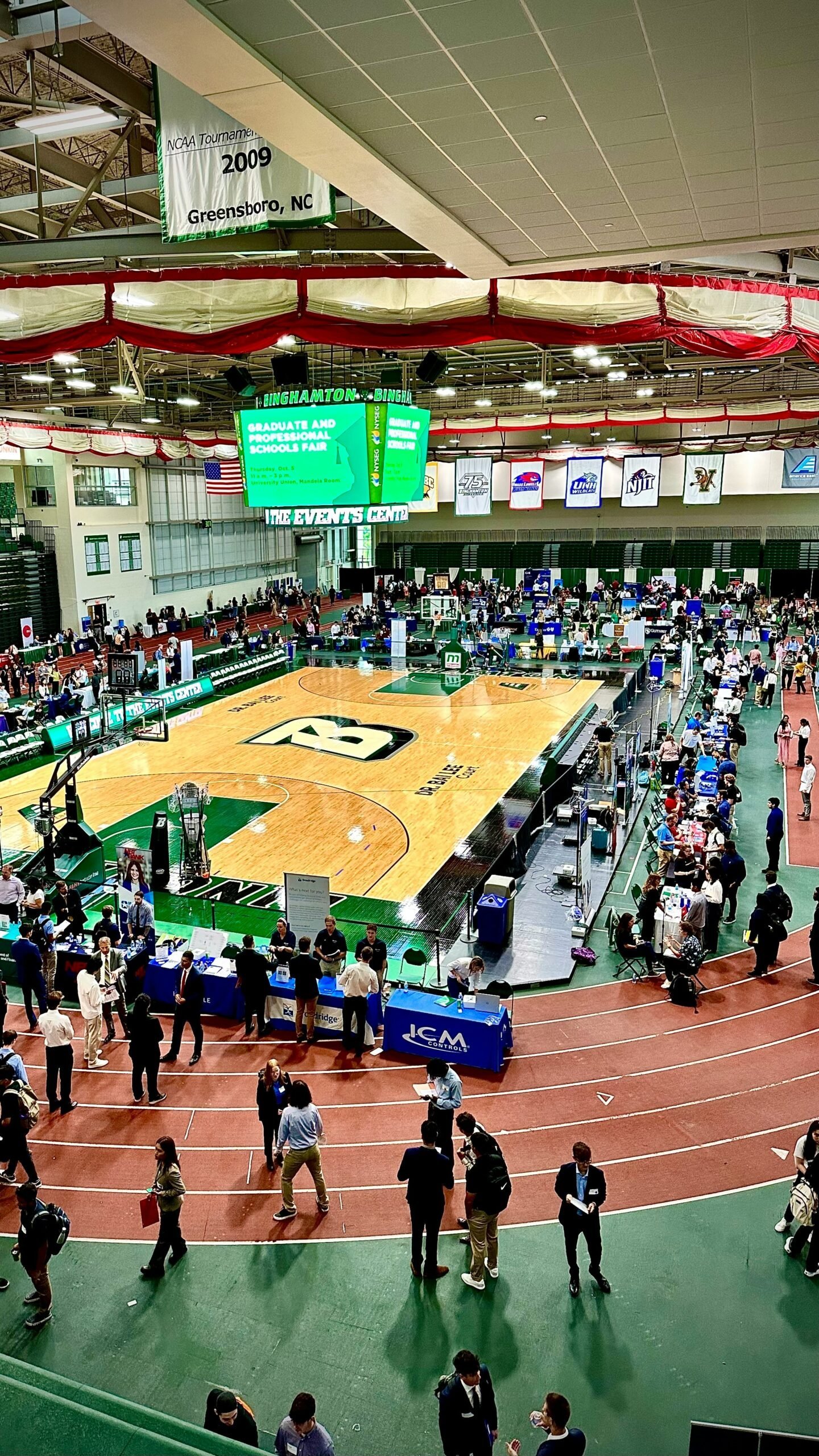 a crowd of people standing around a basketball court